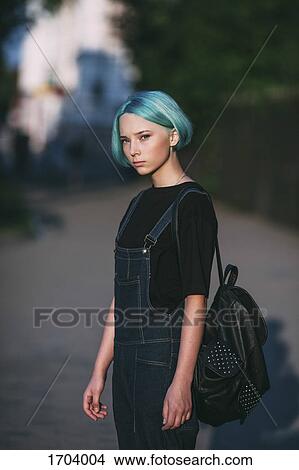 Portrait of teenage girl carrying backpack while standing on road View Large Photo Image Picture - Portrait of teenage girl carrying backpack while standing on road. Fotosearch