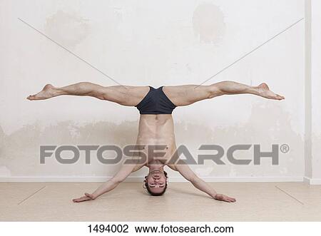 Portrait of upside down man with legs apart performing headstand yoga exercise View Large Photo Image Stock Image - Portrait of upside down man with legs apart performing headstand yoga exercise. Fotosearch