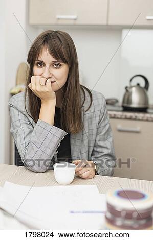 Portrait of woman sitting in kitchen View Large Photo Image Picture - Portrait of woman sitting in kitchen. Fotosearch