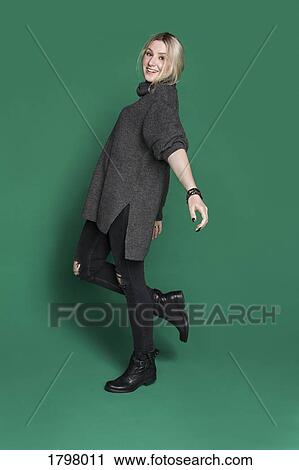 Portrait of woman with blond hair smiling and standing against green background View Large Photo Image Stock Image - Portrait of woman with blond hair smiling and standing against green background. Fotosearch