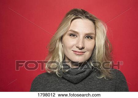 Stock Image - Portrait of woman with blond hair smiling and wearing gray turtleneck sweater. Fotosearch