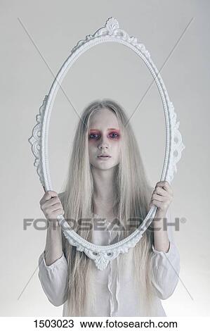 Portrait of woman with spooky red eyes holding picture frame against white background View Large Photo Image Stock Image - Portrait of woman with spooky red eyes holding picture frame against white background. Fotosearch