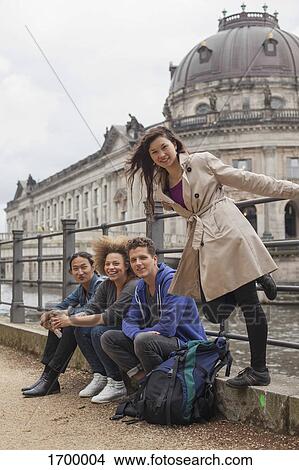 Picture - Portrait of young multi-ethnic friends against Bode Museum, Berlin, Germany. Fotosearch