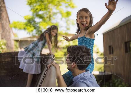 Portrait playful girl with father and sister at wagon in yard View Large Photo Image Stock Photo - Portrait playful girl with father and sister at wagon in yard. Fotosearch