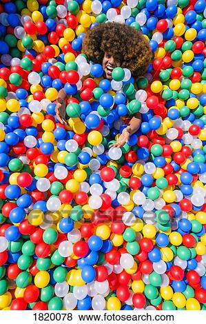 Portrait playful young man in multicolor ball pool View Large Photo Image Stock Photo - Portrait playful young man in multicolor ball pool. Fotosearch