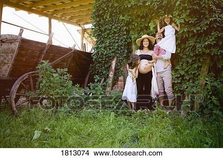 Portrait pregnant family in rural garden View Large Photo Image Picture - Portrait pregnant family in rural garden. Fotosearch