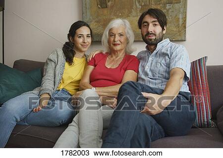 Portrait senior mother sitting with daughter and son on living room sofa View Large Photo Image Stock Image - Portrait senior mother sitting with daughter and son on living room sofa. Fotosearch