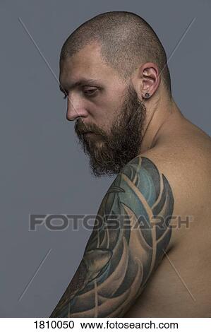 Portrait serious man with beard and tattooed arm View Large Photo Image Stock Image - Portrait serious man with beard and tattooed arm. Fotosearch
