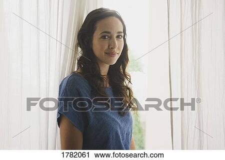 Portrait smiling, confident woman at window View Large Photo Image Stock Image - Portrait smiling, confident woman at window. Fotosearch