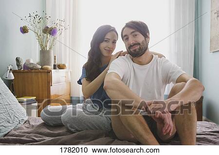 Stock Image - Portrait smiling couple relaxing on bed. Fotosearch