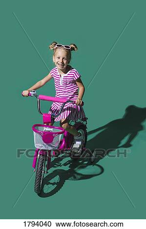 Portrait smiling girl bike riding against green background View Large Photo Image Stock Image - Portrait smiling girl bike riding against green background. Fotosearch