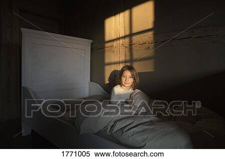 Stock Photography - Portrait smiling girl laying in bed. Fotosearch