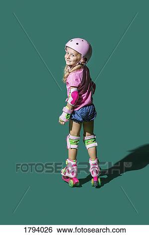 Portrait smiling girl roller skating against green background View Large Photo Image Stock Photograph - Portrait smiling girl roller skating against green background. Fotosearch