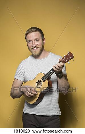 Portrait smiling man playing ukulele View Large Photo Image Stock Image - Portrait smiling man playing ukulele. Fotosearch
