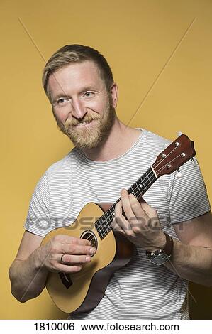 Portrait smiling man playing ukulele View Large Photo Image Stock Photograph - Portrait smiling man playing ukulele. Fotosearch