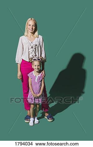Picture - Portrait smiling mother and daughter against green background. Fotosearch