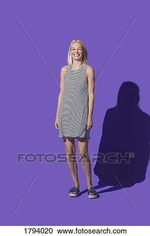 Portrait smiling woman in striped dress against purple background View Large Photo Image Stock Image - Portrait smiling woman in striped dress against purple background. Fotosearch