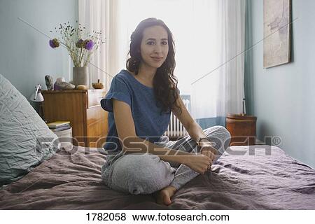 Portrait smiling woman sitting on bed View Large Photo Image Stock Photo - Portrait smiling woman sitting on bed. Fotosearch