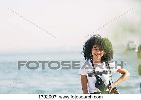 Stock Photo - Portrait smiling young woman at oceanside. Fotosearch