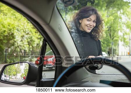 Portrait smiling young woman with smart phone accessing car share View Large Photo Image Stock Image - Portrait smiling young woman with smart phone accessing car share. Fotosearch