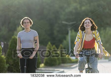 Portrait women friends riding bicycle and push scooter View Large Photo Image Stock Photo - Portrait women friends riding bicycle and push scooter. Fotosearch