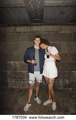 Picture - Portrait young couple drinking beer in basement. Fotosearch