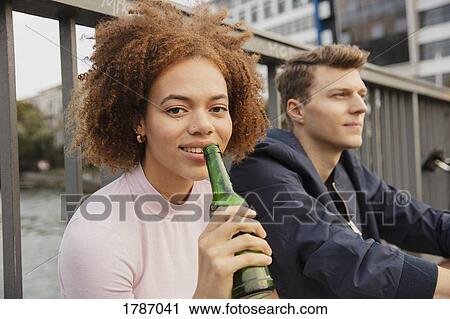 Portrait young woman drinking beer on urban bridge View Large Photo Image Stock Image - Portrait young woman drinking beer on urban bridge. Fotosearch