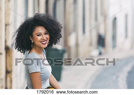 Stock Photograph - Portrait young woman smiling on street. Fotosearch