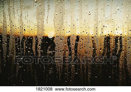 Raindrops and condensation on window with scenic sunset view View Large Photo Image Stock Photo - Raindrops and condensation on window with scenic sunset view. Fotosearch