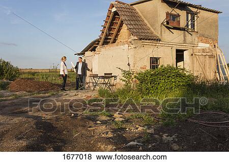 Real estate agent talking to woman while standing outside house against sky View Large Photo Image Stock Photo - Real estate agent talking to woman while standing outside house against sky. Fotosearch