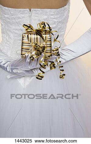 Rear view midsection of bride holding gift box View Large Photo Image Stock Photography - Rear view midsection of bride holding gift box. Fotosearch