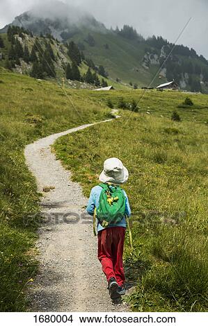 Picture - Rear view of boy walking on mountain trail, Wildberg, Switzerland. Fotosearch