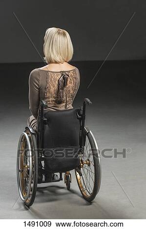 Rear view of disabled woman in wheelchair View Large Photo Image Stock Photo - Rear view of disabled woman in wheelchair. Fotosearch