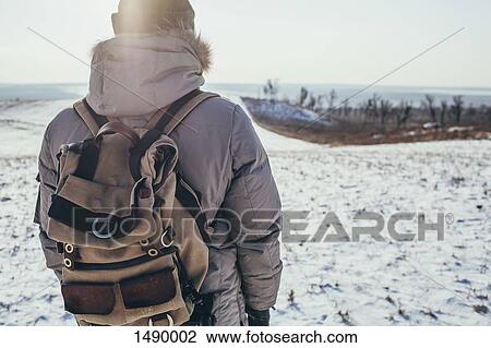 Rear view of hiker standing on snow covered landscape View Large Photo Image Stock Image - Rear view of hiker standing on snow covered landscape. Fotosearch