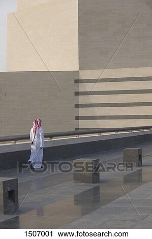 Rear view of man walking on floor by railing View Large Photo Image Stock Image - Rear view of man walking on floor by railing. Fotosearch