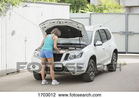 Rear view of mature woman fixing vehicle View Large Photo Image Stock Image - Rear view of mature woman fixing vehicle. Fotosearch