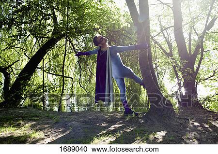 Rear view of superhero standing by tree at riverbank on sunny day View Large Photo Image Stock Image - Rear view of superhero standing by tree at riverbank on sunny day. Fotosearch