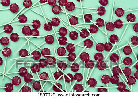 Stock Photo - Red lollipops against green background. Fotosearch