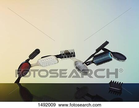 Reflection of hairbrushes in mid-air on glass table View Large Photo Image Stock Photo - Reflection of hairbrushes in mid-air on glass table. Fotosearch