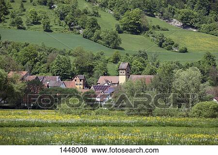 Scenic view of grassy field by houses against mountain View Large Photo Image Stock Photo - Scenic view of grassy field by houses against mountain. Fotosearch