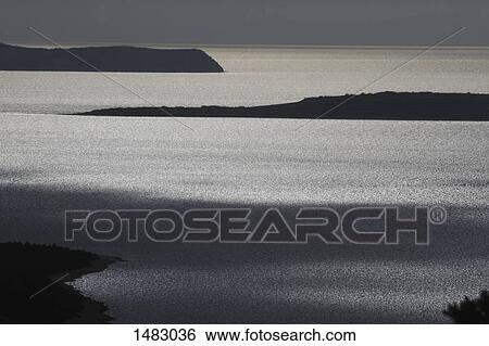 Stock Photograph - Scenic view of lake and mountain during sunset. Fotosearch