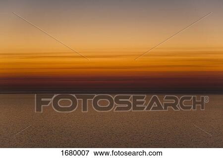 Scenic view of sea against orange sky during sunset View Large Photo Image Stock Photo - Scenic view of sea against orange sky during sunset. Fotosearch