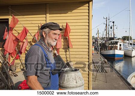 Senior man standing at harbor by boats moored at lake View Large Photo Image Stock Image - Senior man standing at harbor by boats moored at lake. Fotosearch