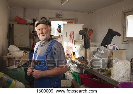 Senior man standing in storage room View Large Photo Image Stock Photo - Senior man standing in storage room. Fotosearch