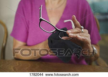 Senior woman cleaning eyeglasses View Large Photo Image Picture - Senior woman cleaning eyeglasses. Fotosearch