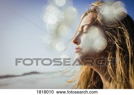 Serene woman basking in sunshine on beach View Large Photo Image Stock Image - Serene woman basking in sunshine on beach. Fotosearch
