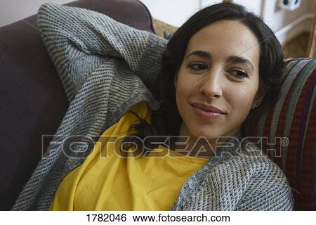 Serene woman relaxing on sofa View Large Photo Image Stock Photograph - Serene woman relaxing on sofa. Fotosearch