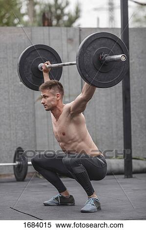Shirtless male athlete lifting barbell during crossfit training View Large Photo Image Stock Photography - Shirtless male athlete lifting barbell during crossfit training. Fotosearch