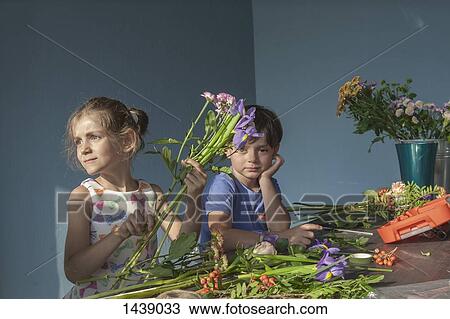 Siblings arranging flowers at table View Large Photo Image Stock Image - Siblings arranging flowers at table. Fotosearch