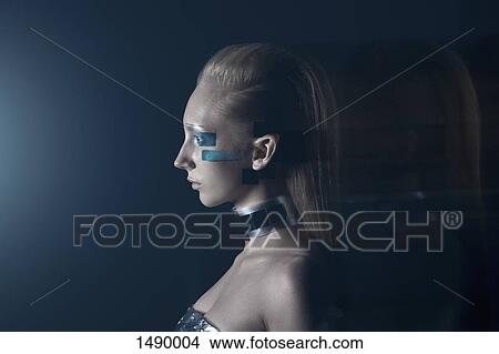 Picture - Side view of confident fashion model against blue background. Fotosearch